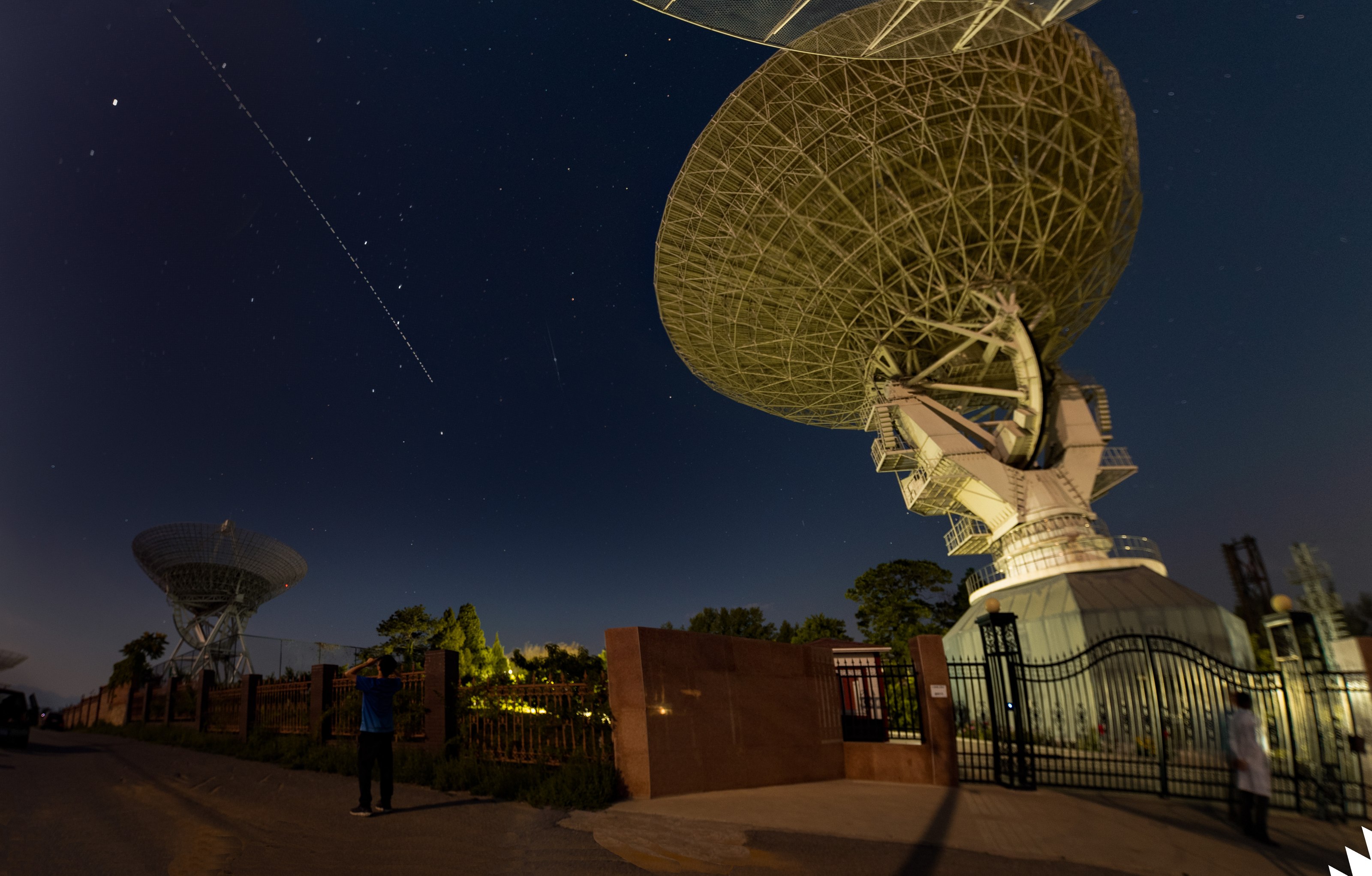 Radio telescope beneath a star-filled night sky